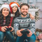 Famille heureuse jouant aux jeux vidéo à Noël. Trouvez le cadeau de Noël idéal pour les gamers. Conseils et astuces pour sélectionner les meilleurs jeux et accessoires pour une fête inoubliable.