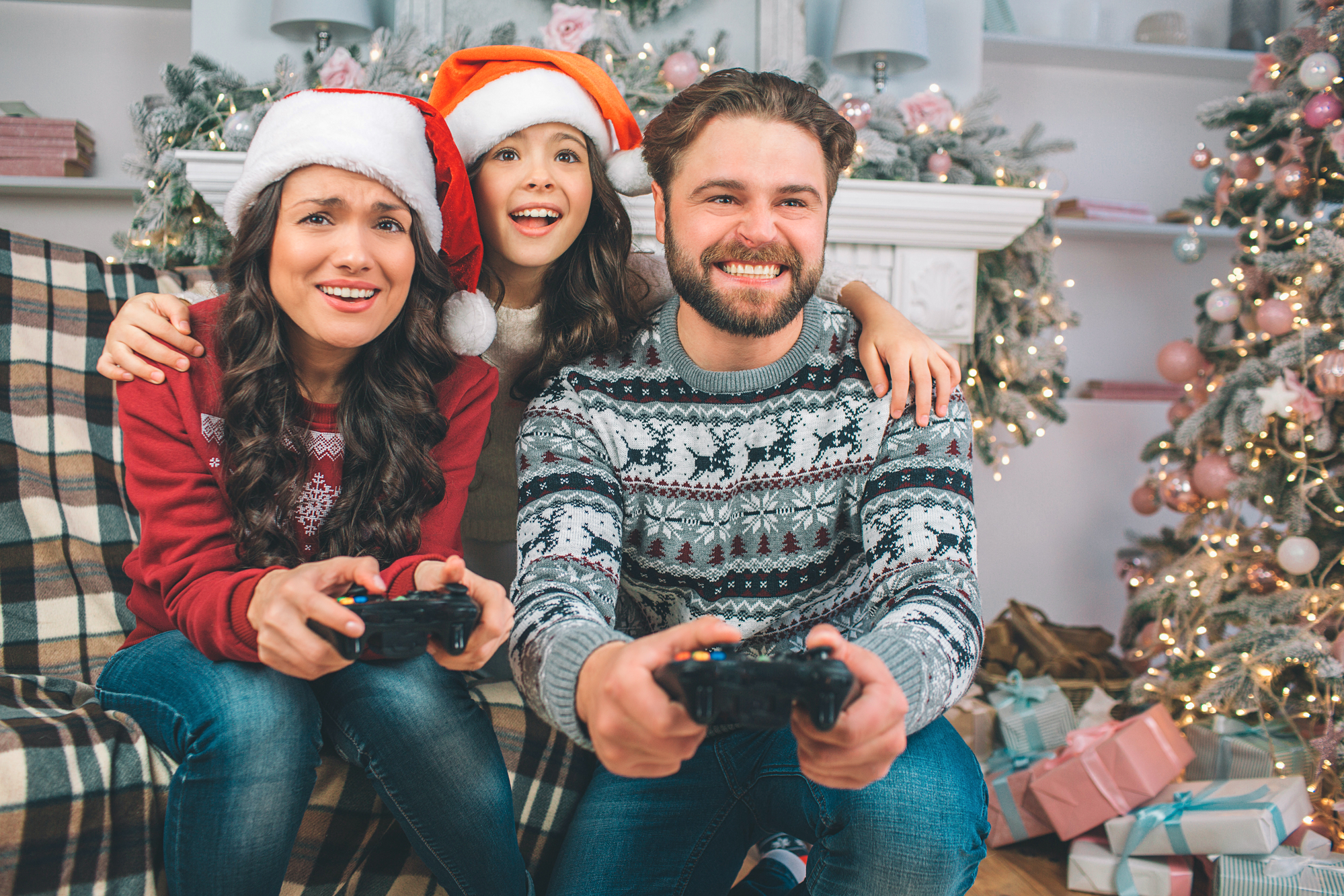 Famille heureuse jouant aux jeux vidéo à Noël. Trouvez le cadeau de Noël idéal pour les gamers. Conseils et astuces pour sélectionner les meilleurs jeux et accessoires pour une fête inoubliable.